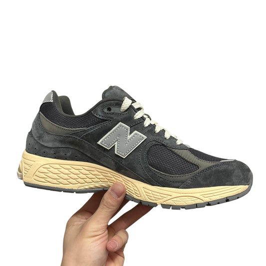 Luxury Chef New Balance 2002R dark grey suede and mesh sneakers with cream sole and white laces.