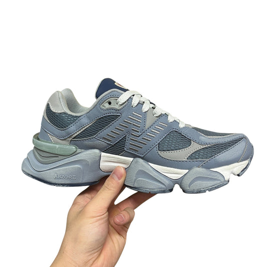 Luxury Chef New Balance 9060 sneakers in light blue and grey with white laces and ABZORB sole.
