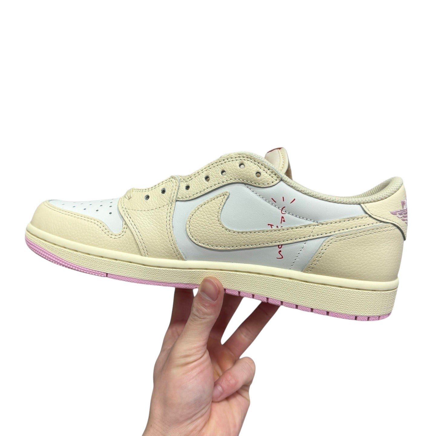 Luxury Chef Air Jordan 1 Low Travis Scott sneakers in cream and white leather with pink accents and red stitching.
