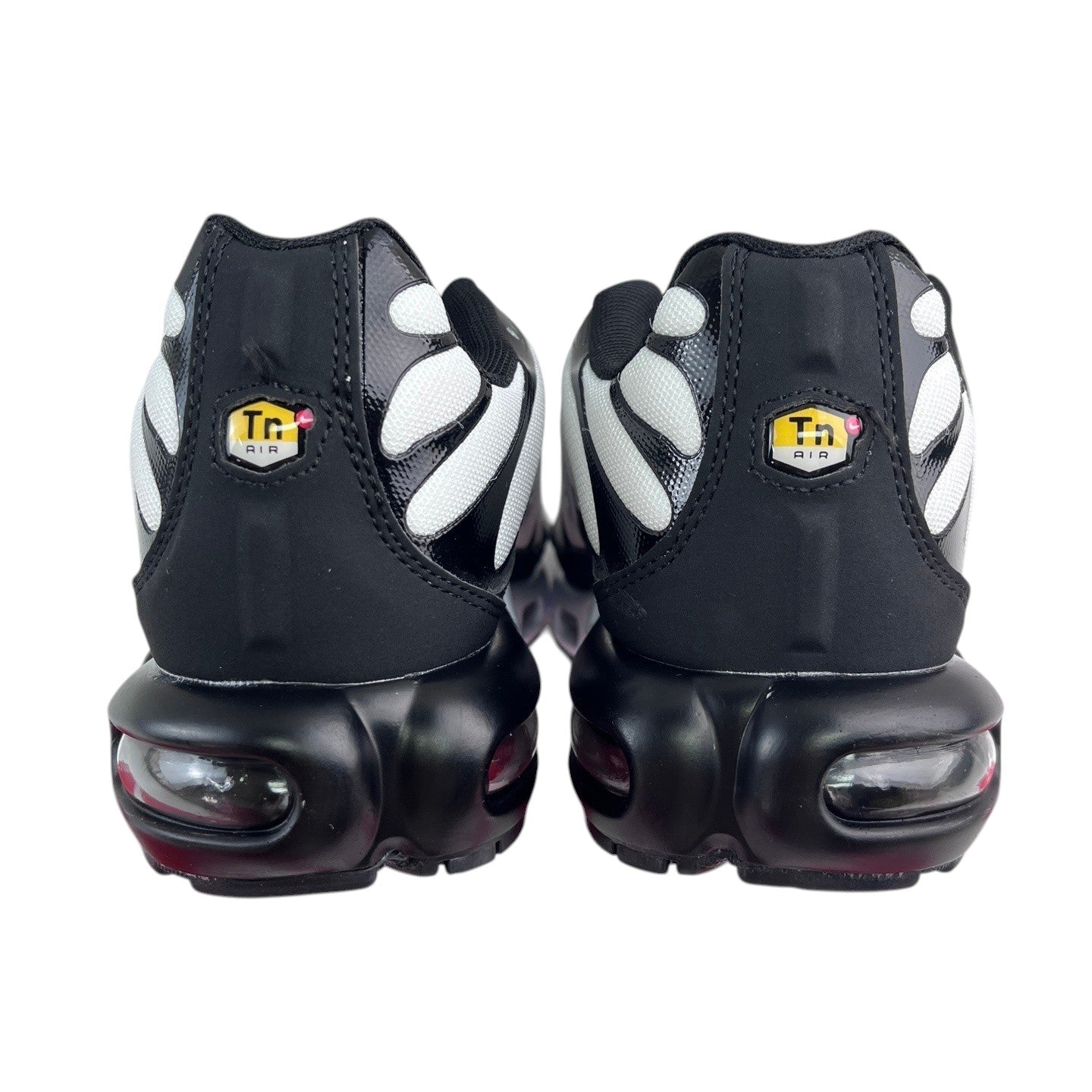 Luxury Chef Nike TN Air Max Plus sneakers in black with white accents and visible air cushioning. Iconic Tn Air logo on heel.