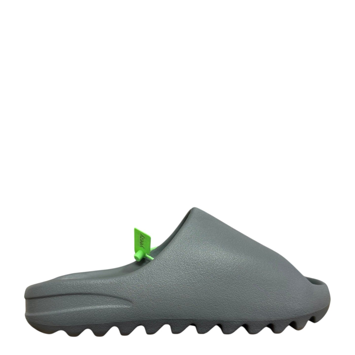 Luxury Chef YEEZY SLIDE in granite grey, featuring a textured EVA foam construction and a serrated sole. Includes bright green YEEZY tags.