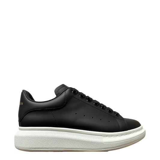 Luxury Chef Alexander McQueen black leather sneakers with white platform sole and signature heel tab.