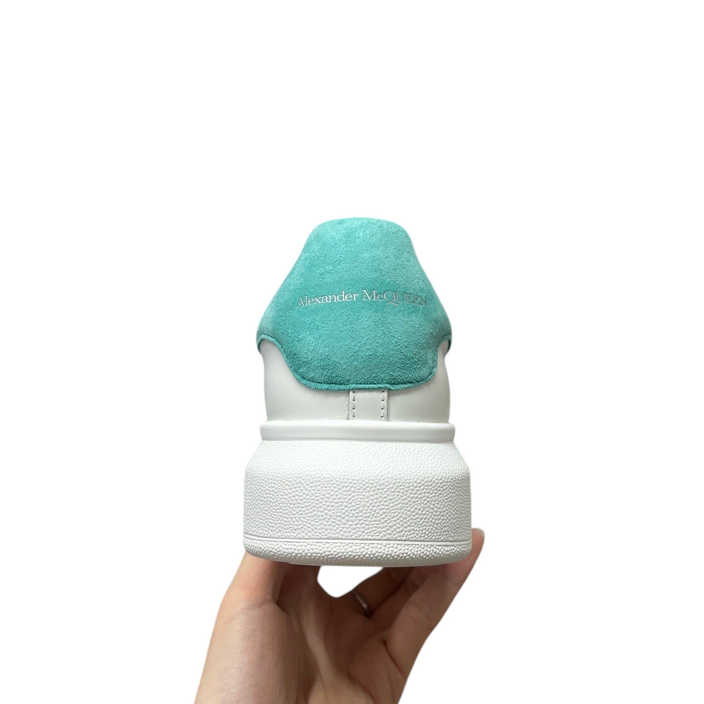Luxury Chef white leather sneakers with a teal suede heel tab featuring Alexander McQueen branding.