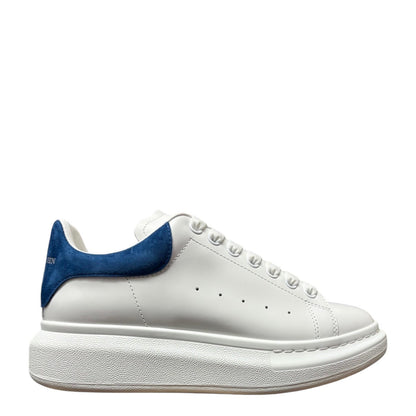 Luxury Chef Alexander McQueen white leather sneakers with blue suede heel tab and chunky sole.