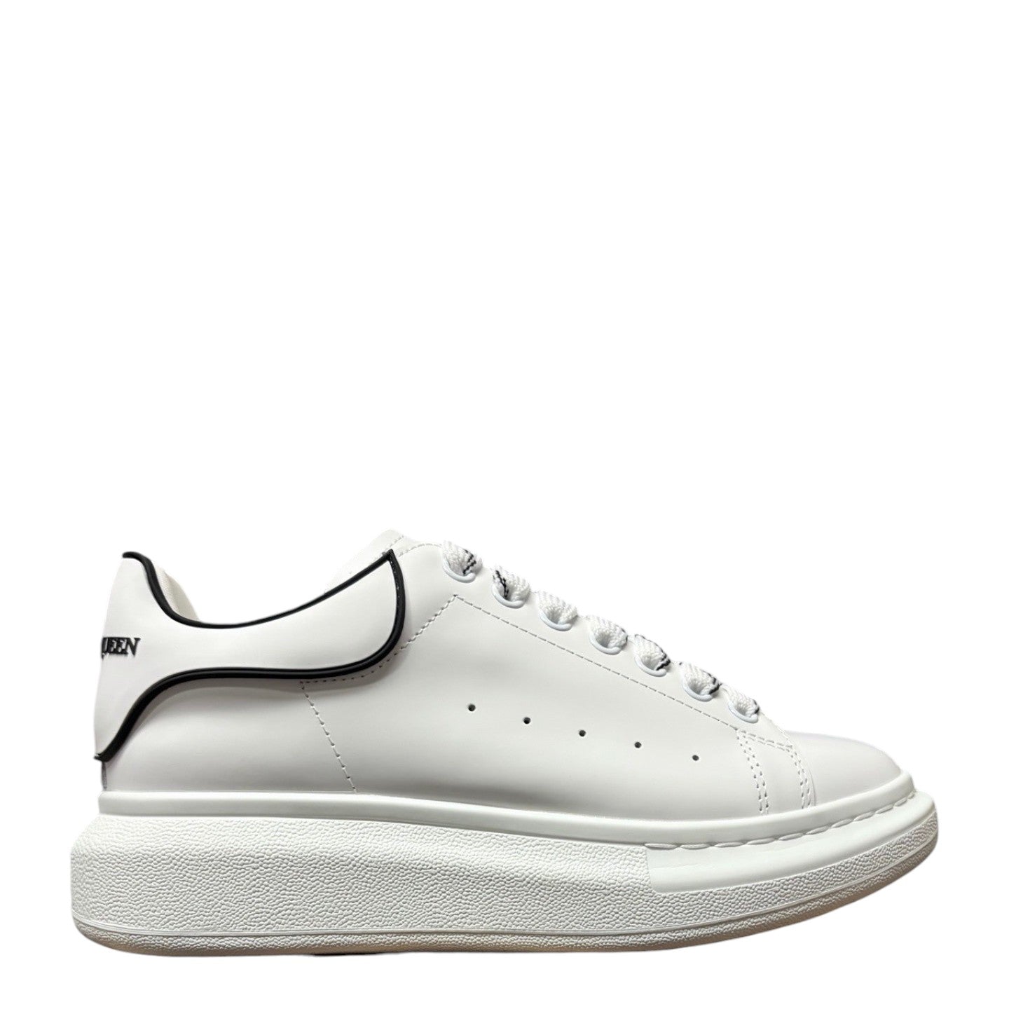 Luxury Chef Alexander McQueen white leather sneakers with black trim and oversized sole.