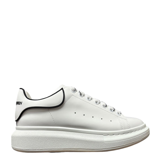 Luxury Chef Alexander McQueen white leather sneakers with black trim and oversized sole.