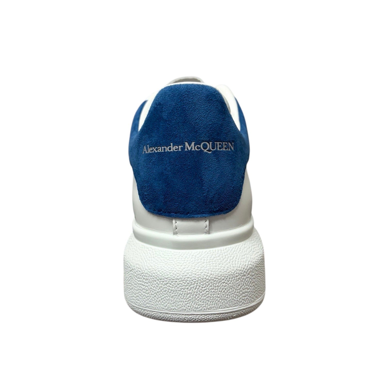 Luxury Chef Alexander McQueen white leather sneakers with blue suede heel tab and embossed logo.
