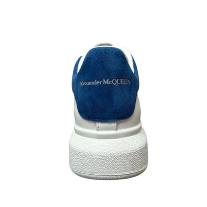Luxury Chef Alexander McQueen white leather sneakers with blue suede heel tab and embossed logo.
