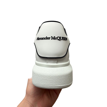 Luxury Chef white leather sneakers with Alexander McQueen logo on heel and chunky sole.