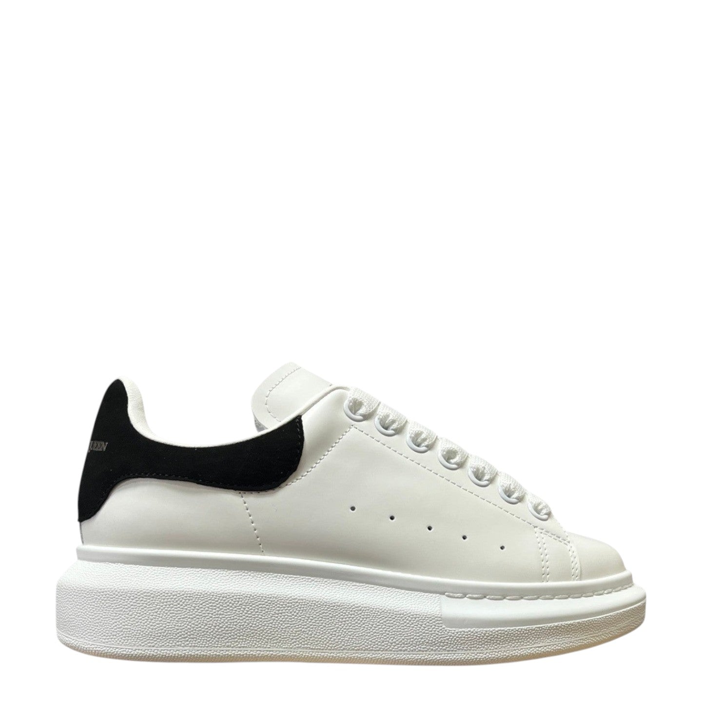 Luxury Chef Alexander McQueen white leather sneakers with black heel tab and chunky sole.