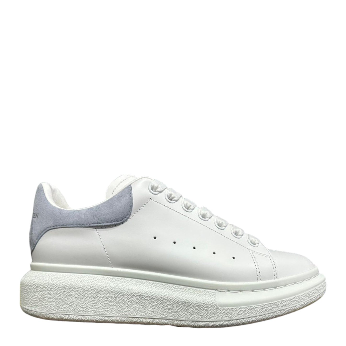 Luxury Chef Alexander McQueen white leather sneakers with light grey suede heel detail and chunky sole.