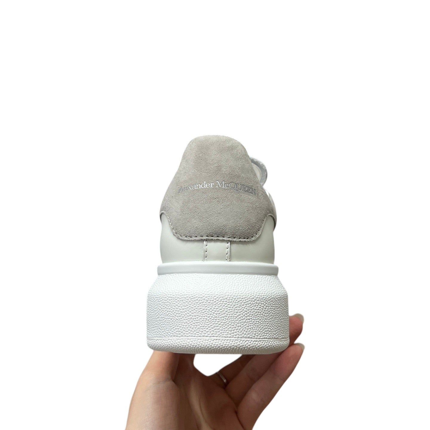 Luxury Chef Alexander McQueen white leather sneakers with grey suede heel tab and embossed logo.