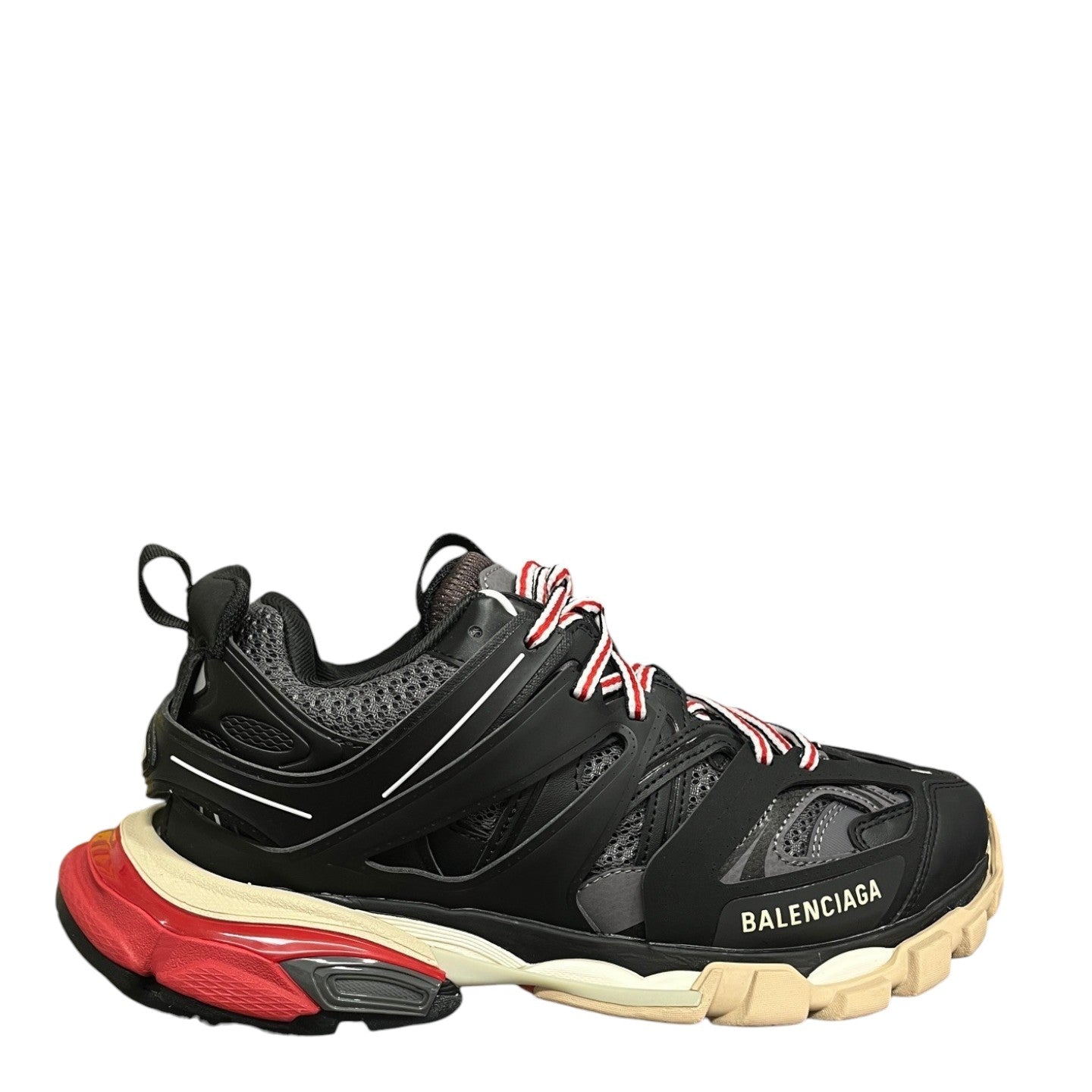Luxury Chef Balenciaga Track sneakers in black, red, and beige with a chunky sole and red and white laces.