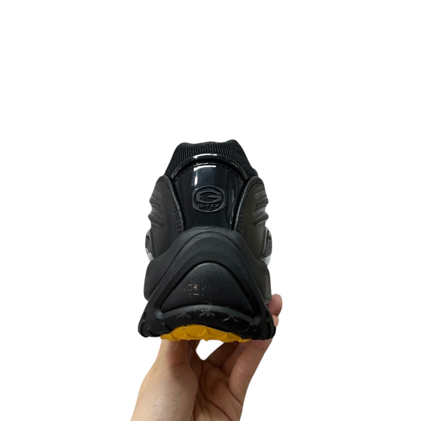 Luxury Chef NOCTA HOT STEP black sneakers with yellow sole and G-TEK logo detail.
