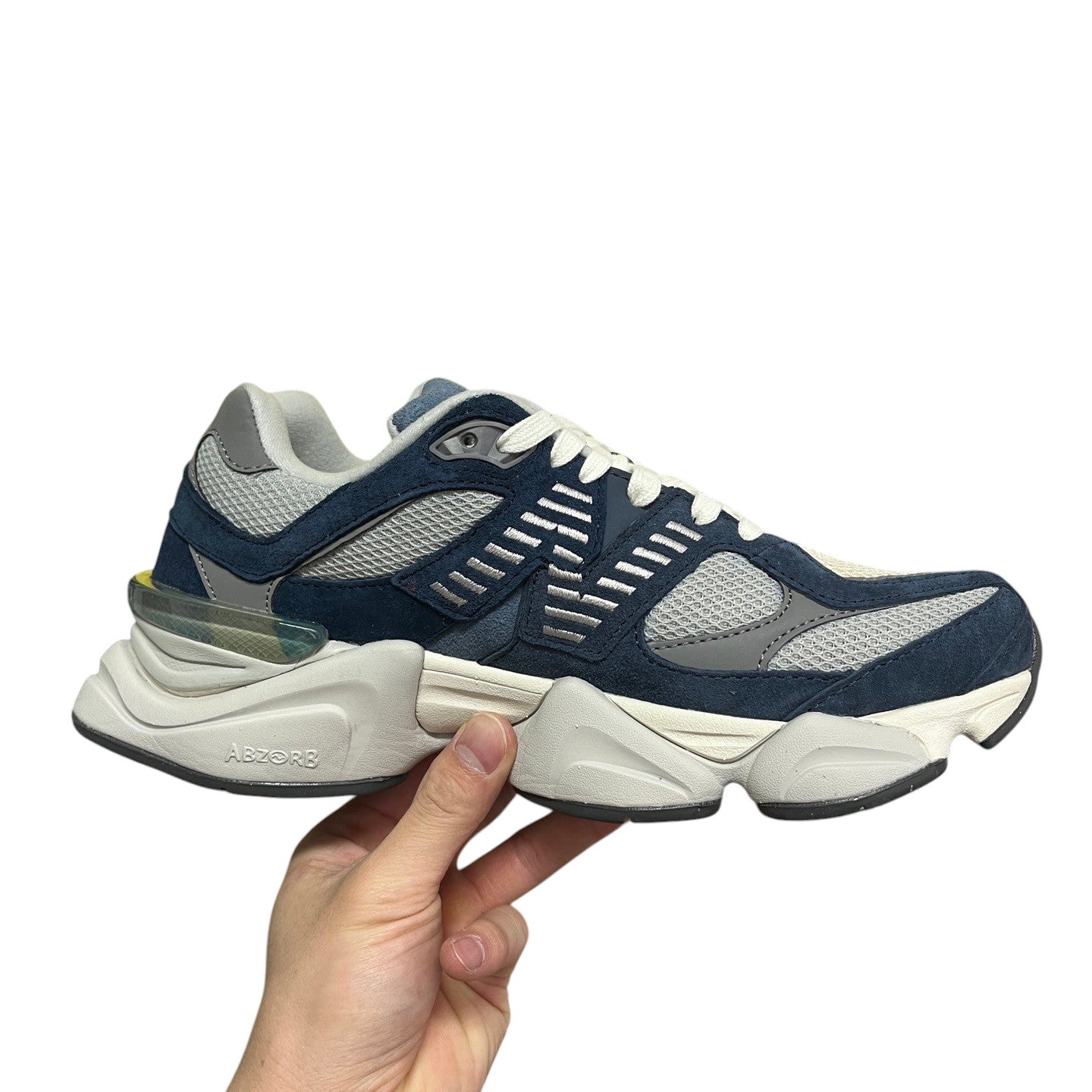 Luxury Chef New Balance 9060 navy blue suede and mesh sneakers with white laces and ABZORB sole.