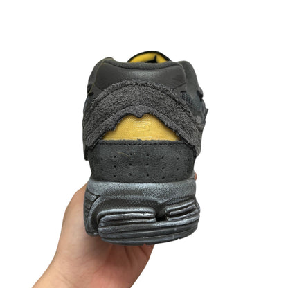 Luxury Chef NEW BALANCE 2002R dark grey suede and leather sneakers with yellow heel accent.