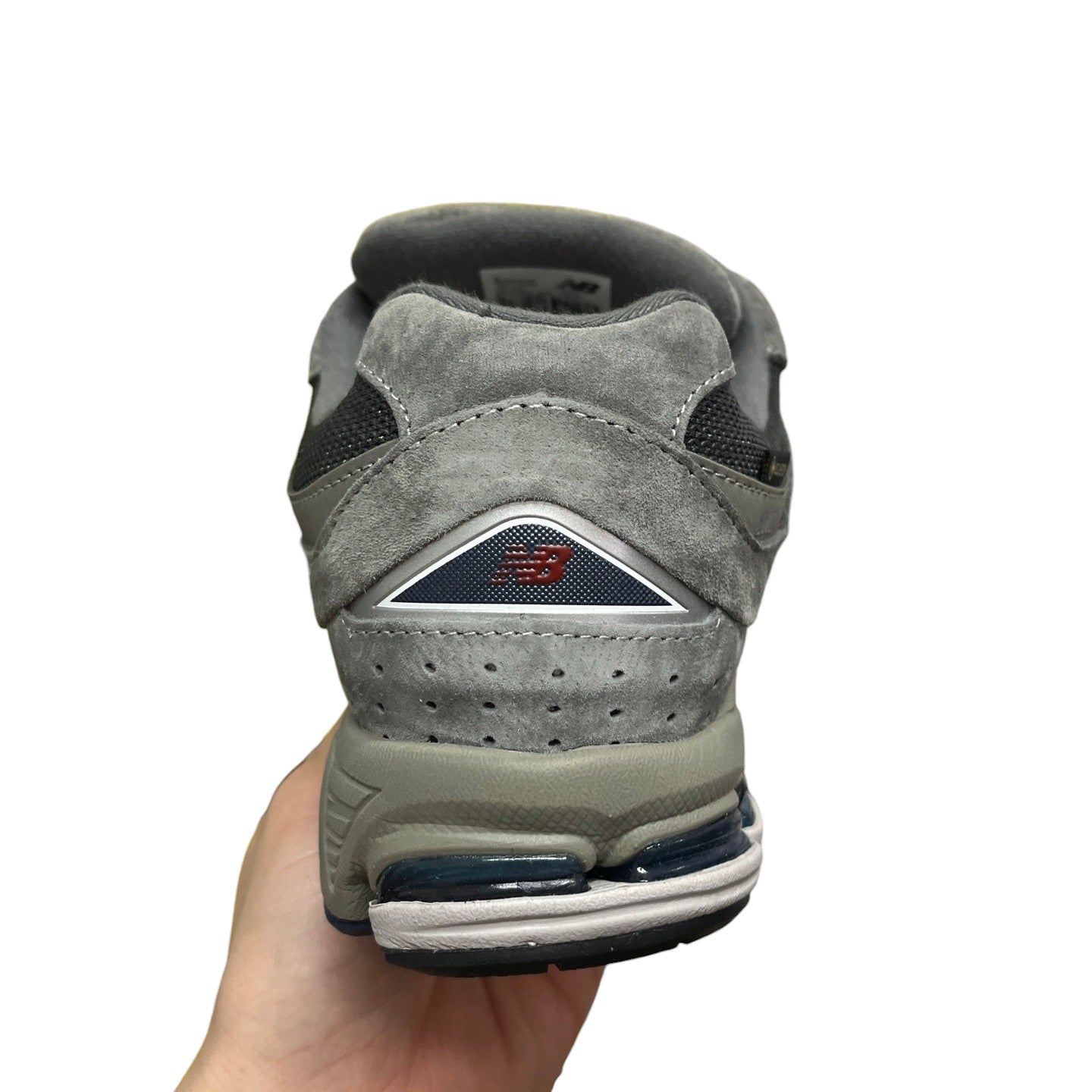Luxury Chef New Balance 2002R grey suede sneakers with blue accents and white sole.
