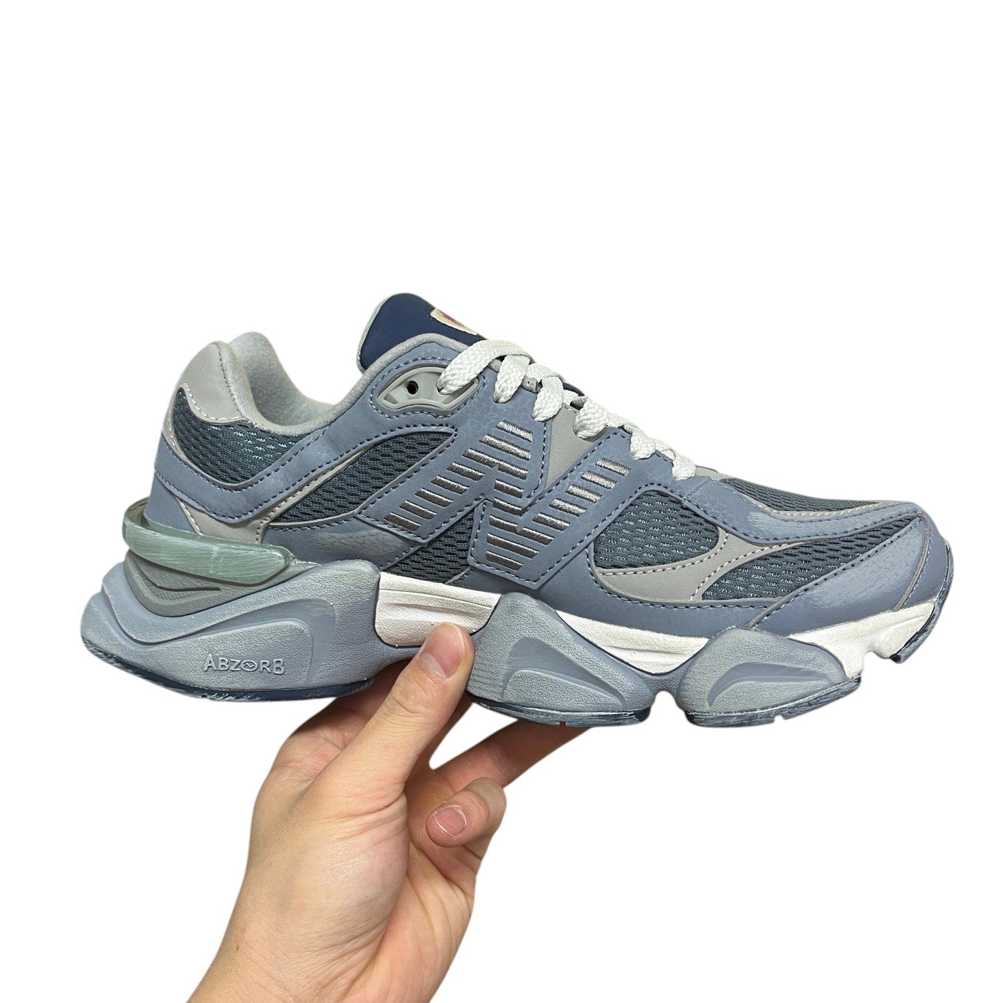 Luxury Chef New Balance 9060 sneakers in light blue and grey with white laces and ABZORB sole.