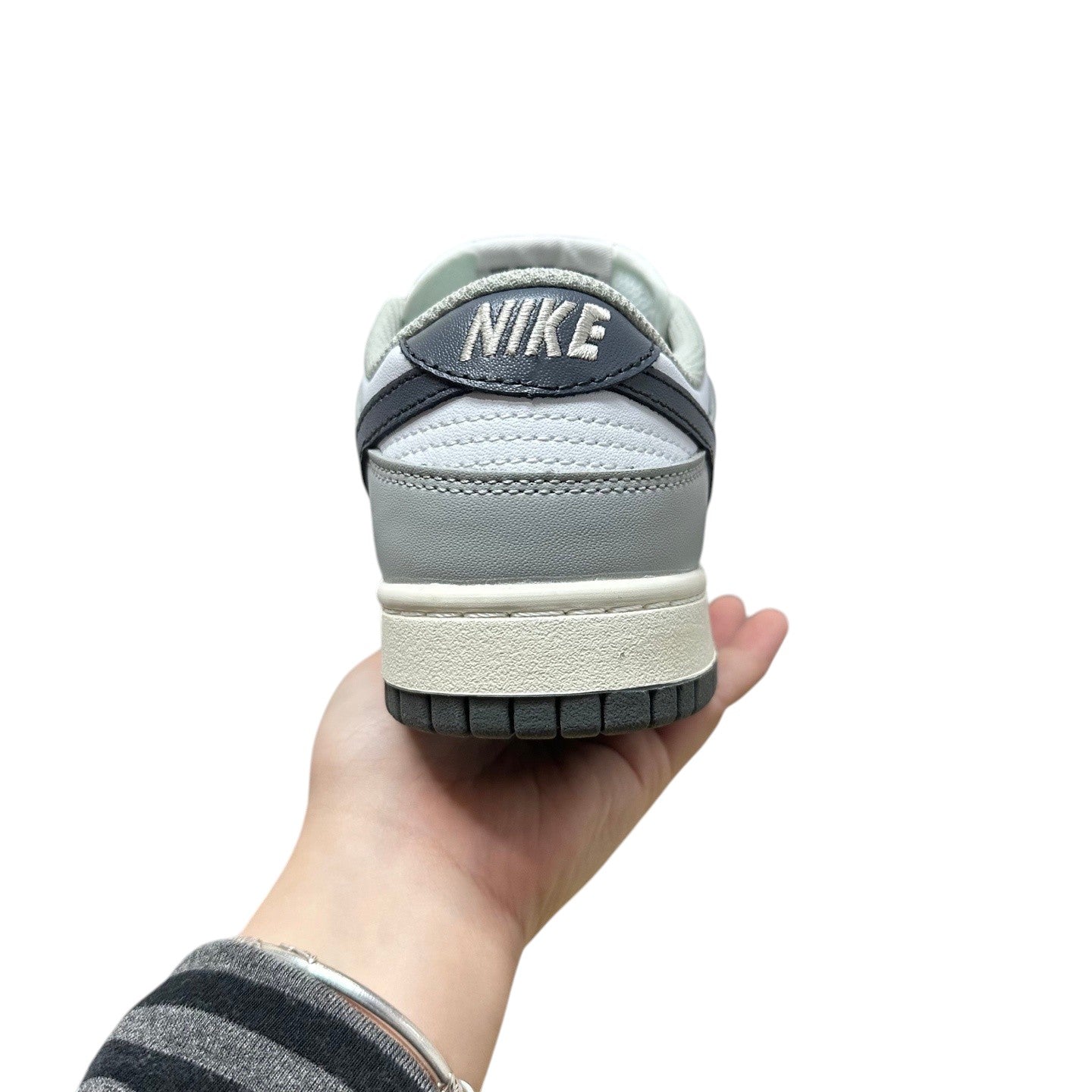 Luxury Chef Nike Dunk Low grey and white leather sneakers with embroidered Nike logo on heel tab.