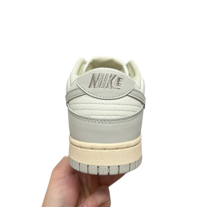 Luxury Chef Nike Dunk Low off-white and grey leather sneakers with embroidered Nike logo on heel.