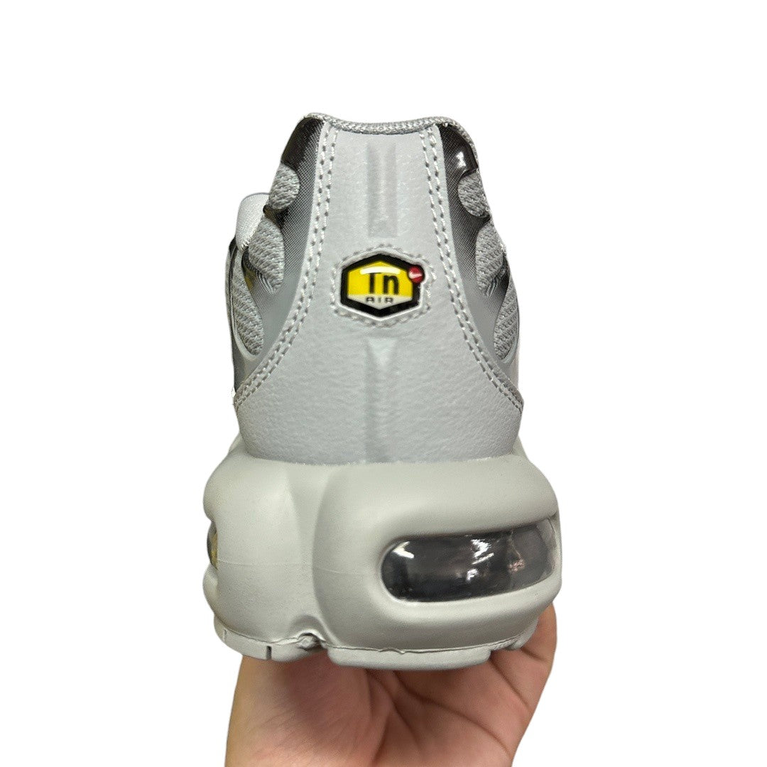 Luxury Chef Nike TN Air Max sneakers in light grey with yellow Tn Air logo detail and visible air cushioning.