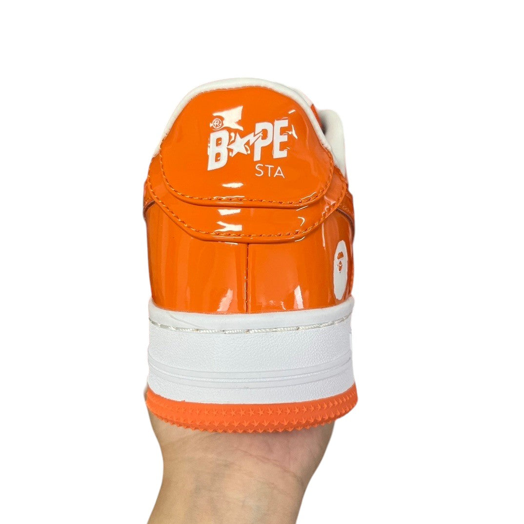 Luxury Chef BAPESTA sneakers in shiny orange patent leather with white accents and BAPE branding.
