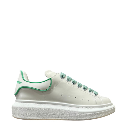 Luxury Chef white leather sneakers with green accents and laces, featuring a chunky platform sole and Alexander McQueen branding on the heel.
